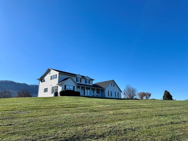 view of front of house with a rural view and a front lawn