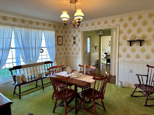 dining space featuring a notable chandelier, ornamental molding, and a textured ceiling