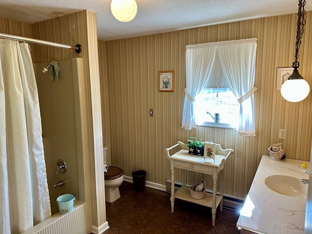 full bathroom with vanity, a textured ceiling, toilet, and shower / bath combo with shower curtain