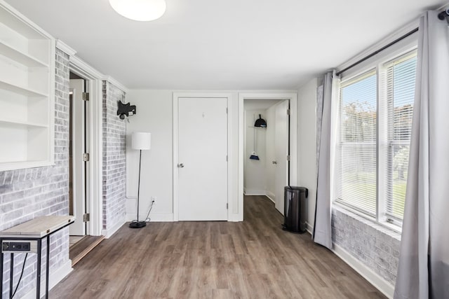 411 Courtland Cir, Galax, VA 24333 - unfurnished living room with wood finished floors, brick wall, and baseboards