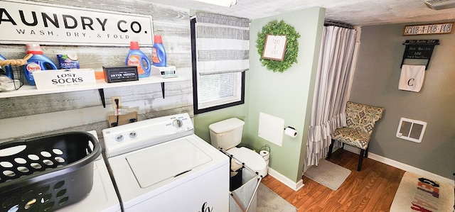 washroom with washing machine and clothes dryer and wood-type flooring