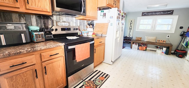 kitchen featuring stainless steel appliances and dark stone counters