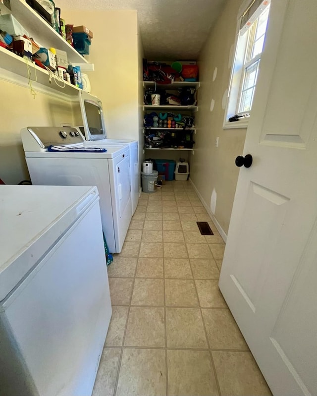 washroom with washer and dryer, visible vents, laundry area, and light tile patterned flooring