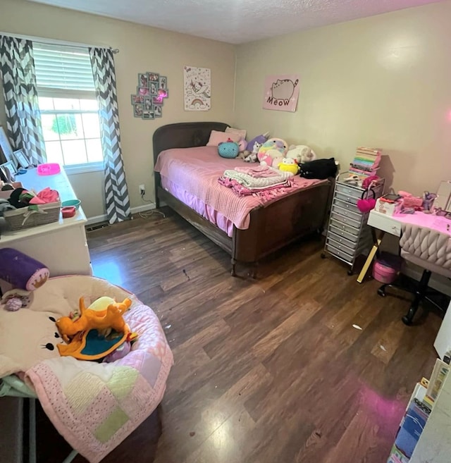 bedroom featuring baseboards and wood finished floors