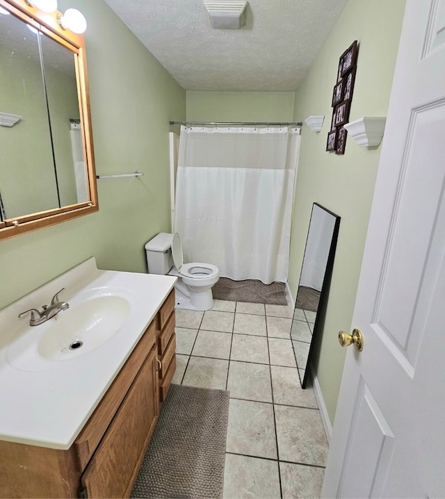 full bath featuring a textured ceiling, vanity, visible vents, toilet, and tile patterned floors