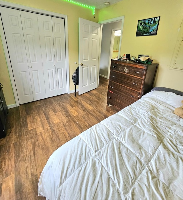 bedroom with a closet, baseboards, and wood finished floors