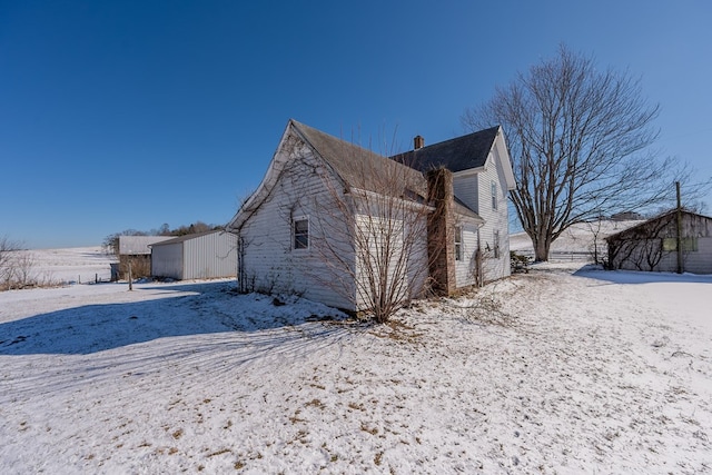 view of snow covered rear of property