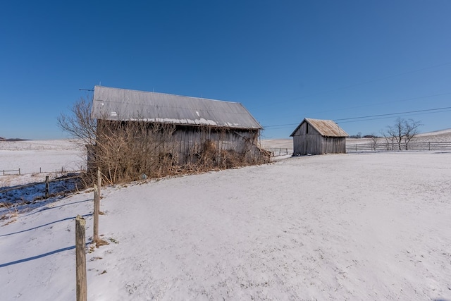 yard layered in snow featuring an outdoor structure