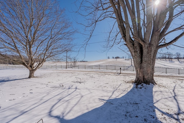 snowy yard featuring a rural view