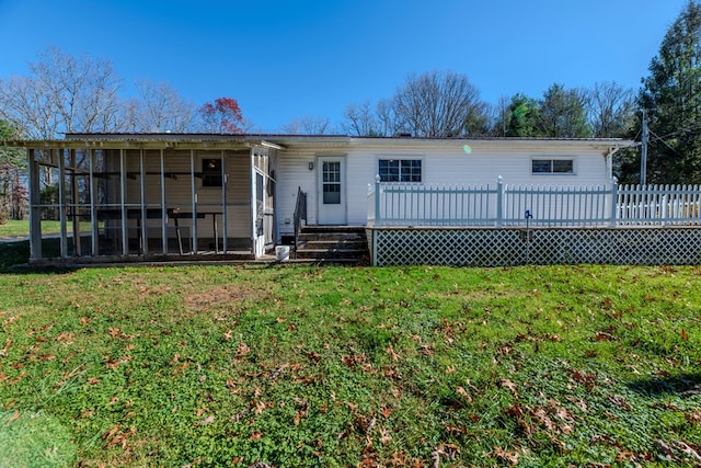 view of front of house featuring a front lawn, a sunroom, and a wooden deck