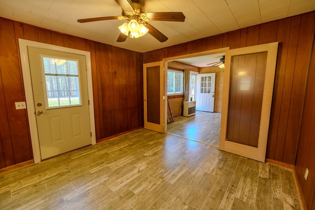 interior space featuring wooden walls, light hardwood / wood-style floors, and a healthy amount of sunlight