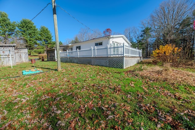 back of property featuring a wooden deck and a yard