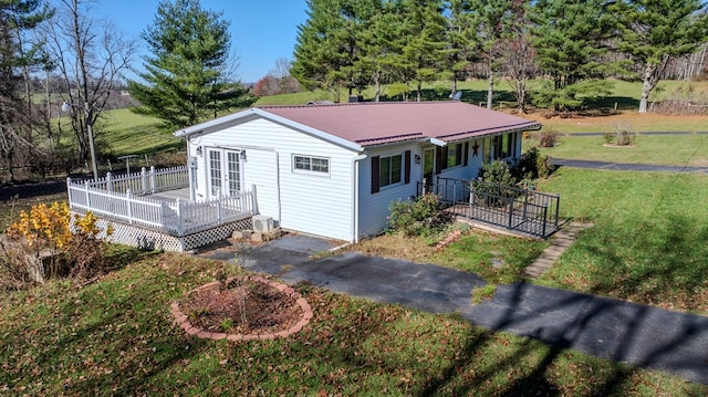 rear view of house with a wooden deck, a yard, and covered porch