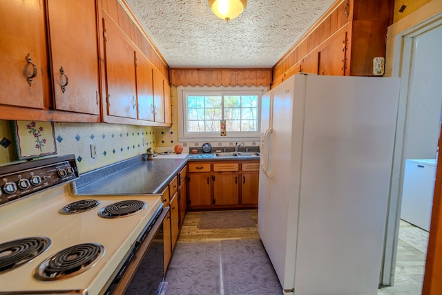 kitchen with range with electric stovetop, tasteful backsplash, sink, white refrigerator with ice dispenser, and a textured ceiling