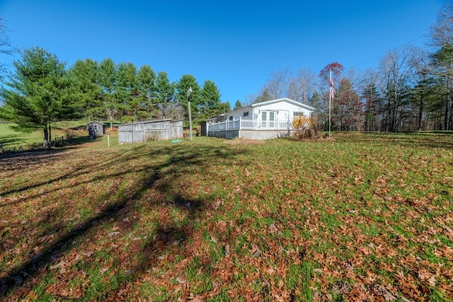 view of yard featuring a storage unit and a deck