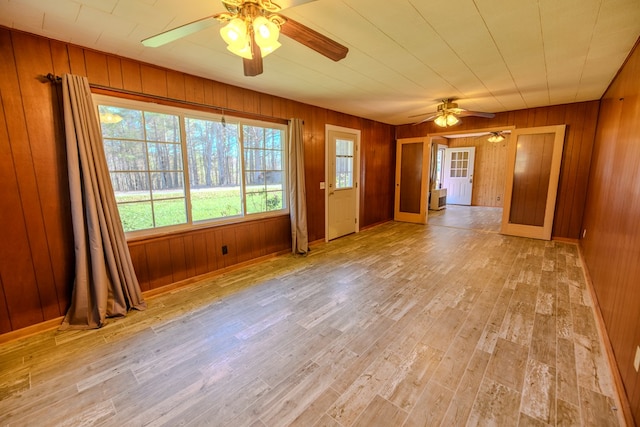 empty room with wooden walls and light wood-type flooring