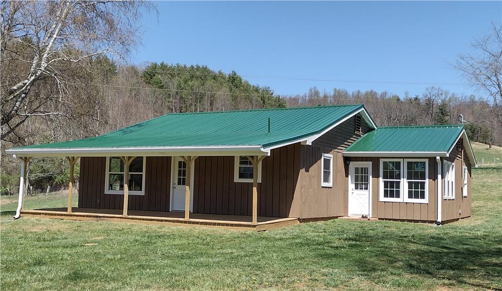 7387 Floyd Pike, Dugspur, VA 24325 - view of front of property featuring metal roof, covered porch, and a front yard