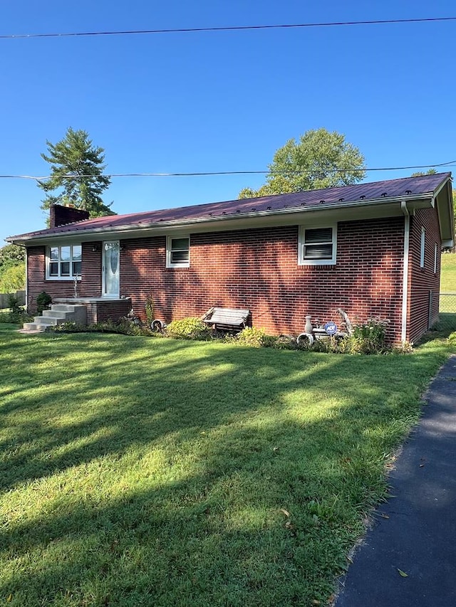 128 Roberts Chapel Rd, Saltville, VA 24370 - view of home's exterior featuring brick siding and a lawn