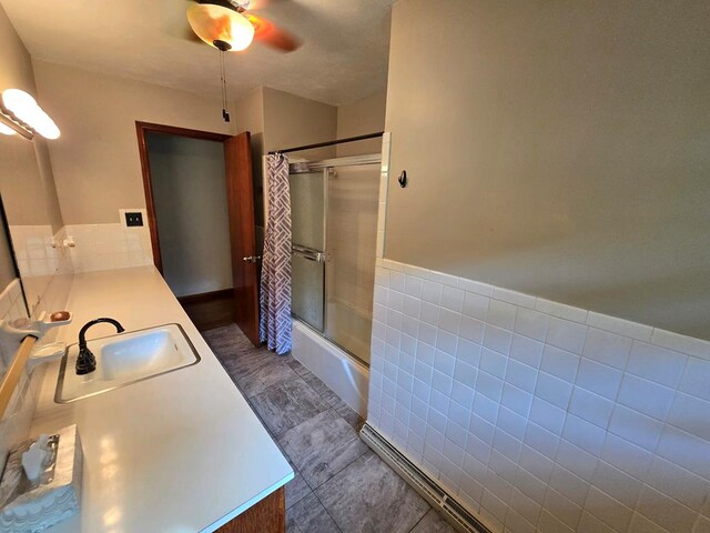 128 Roberts Chapel Rd, Saltville, VA 24370 - bathroom featuring double vanity, ceiling fan, enclosed tub / shower combo, wainscoting, and tile walls