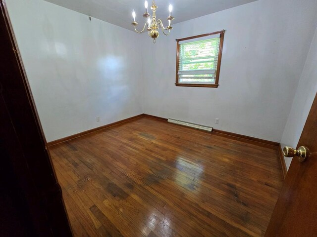 128 Roberts Chapel Rd, Saltville, VA 24370 - spare room with baseboard heating, a chandelier, hardwood / wood-style floors, and baseboards
