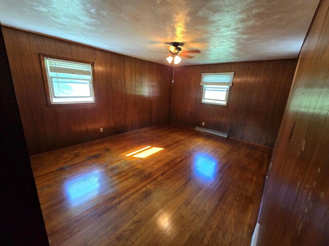 128 Roberts Chapel Rd, Saltville, VA 24370 - unfurnished room featuring a baseboard heating unit, a ceiling fan, and wood finished floors