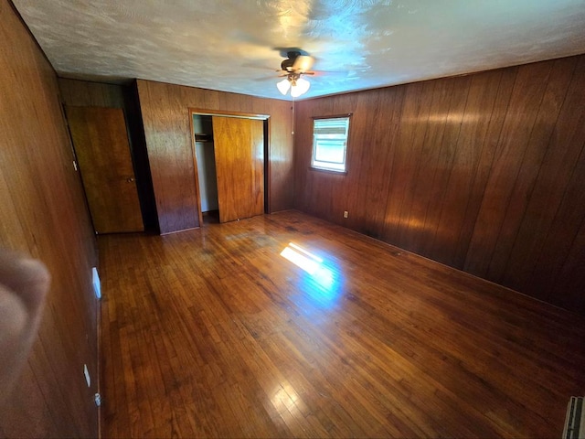 128 Roberts Chapel Rd, Saltville, VA 24370 - unfurnished bedroom featuring wood finished floors, wood walls, and ceiling fan