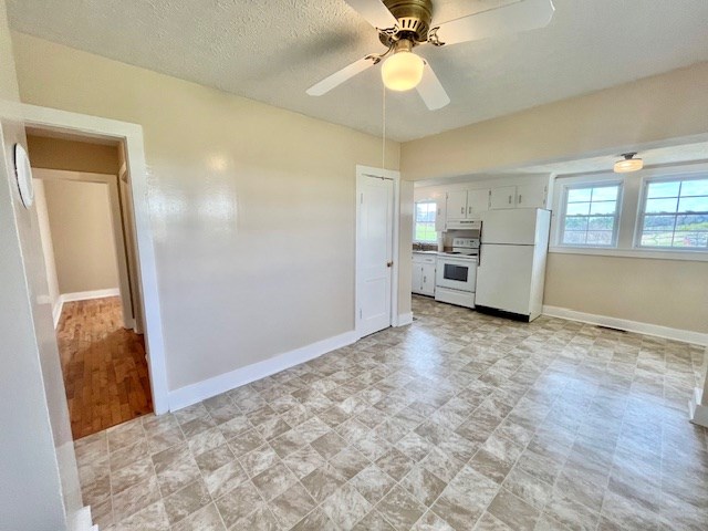 kitchen with white cabinetry, ceiling fan, and white appliances