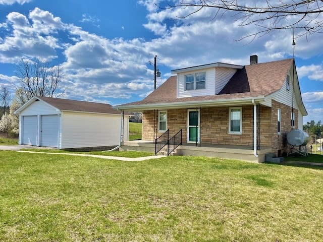 view of front of property with a garage, an outdoor structure, and a front lawn