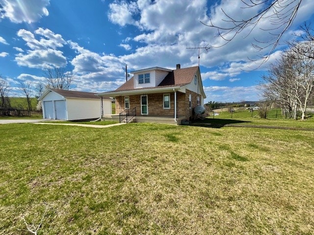 view of front of home featuring an outbuilding, a garage, a front lawn, and a porch