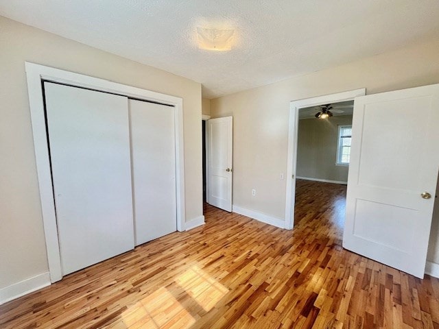 unfurnished bedroom featuring light hardwood / wood-style floors, a closet, and a textured ceiling