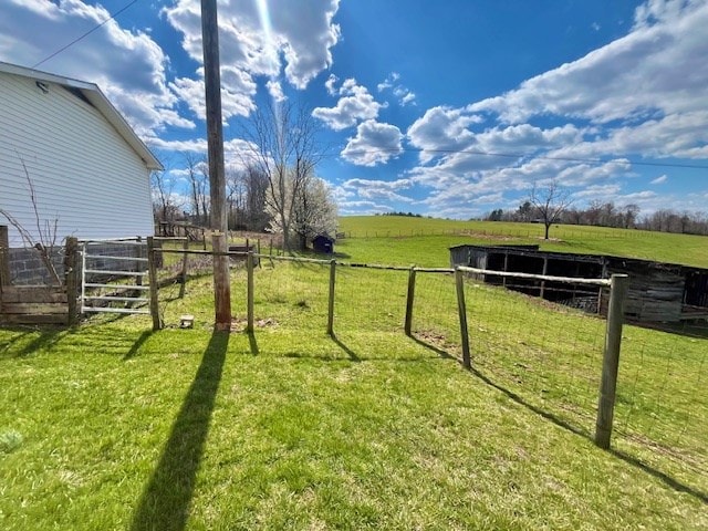 view of yard with an outdoor structure and a rural view