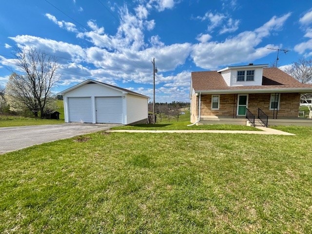 view of front of house with a garage, an outbuilding, and a front lawn