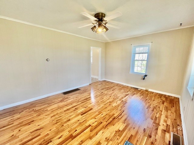 empty room featuring ornamental molding, ceiling fan, and light hardwood / wood-style flooring