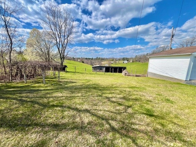 view of yard featuring a rural view and an outbuilding