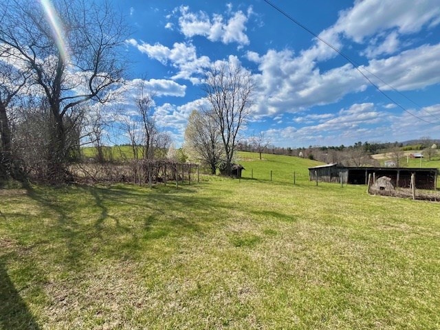 view of yard featuring an outdoor structure and a rural view