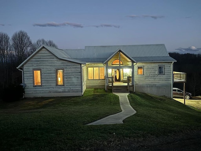 back house at dusk featuring a yard