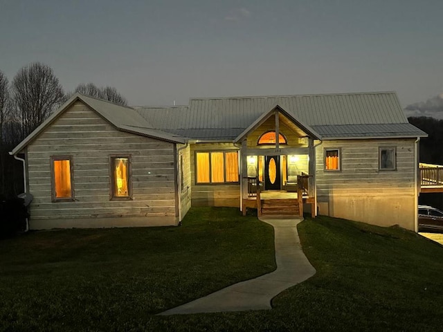 back of property featuring a wooden deck and a lawn