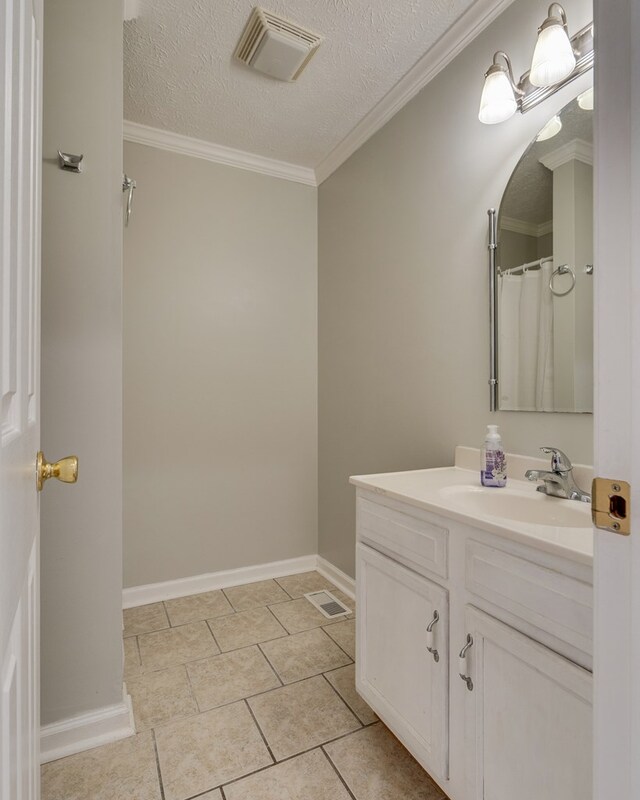 467 Thru Dr, Pounding Mill, VA 24637 - bathroom with vanity, a textured ceiling, tile patterned flooring, and crown molding