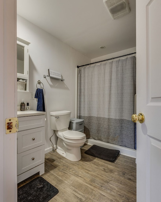 full bath featuring toilet, visible vents, wood finished floors, a shower with shower curtain, and vanity