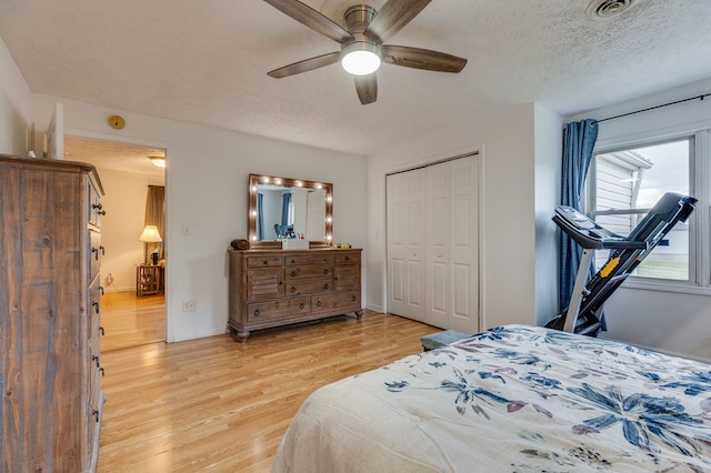 bedroom with a ceiling fan, a closet, light wood finished floors, baseboards, and visible vents