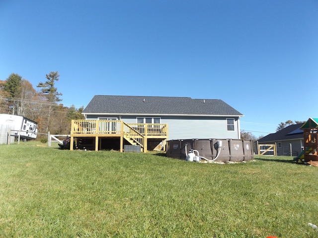 rear view of house with a deck and a lawn