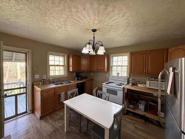 kitchen with a notable chandelier, refrigerator, white electric range oven, dishwasher, and a sink