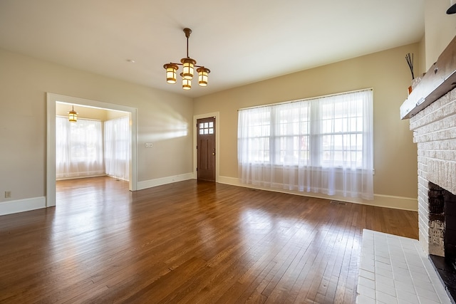 173 S Main St, Hillsville, VA 24343 - unfurnished living room featuring a fireplace, healthy amount of natural light, a chandelier, and hardwood / wood-style floors