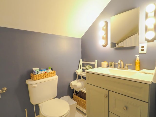bathroom with toilet, lofted ceiling, and vanity