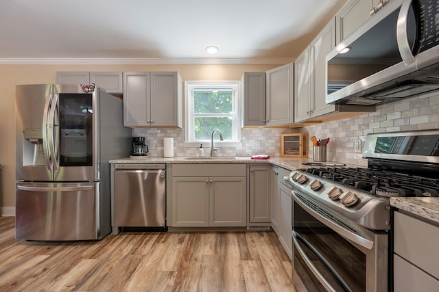 1610 Pope Rd, Ivanhoe, VA 24350 - kitchen featuring appliances with stainless steel finishes, ornamental molding, light wood-style floors, decorative backsplash, and gray cabinetry