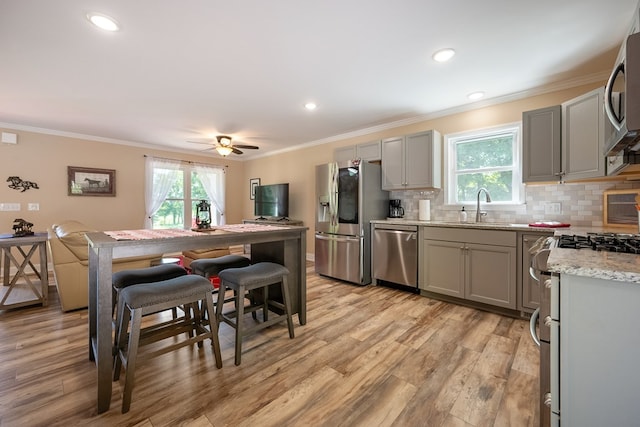 1610 Pope Rd, Ivanhoe, VA 24350 - kitchen with appliances with stainless steel finishes, gray cabinetry, ornamental molding, light wood-type flooring, and a kitchen bar