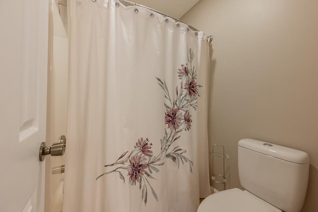 full bath featuring toilet and a shower with shower curtain