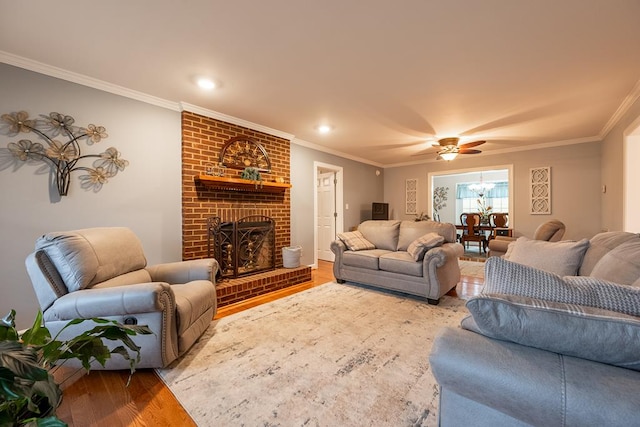 living area featuring a brick fireplace, ornamental molding, wood finished floors, and recessed lighting