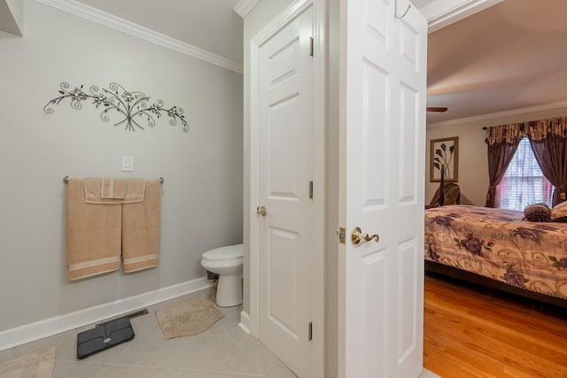 bathroom featuring baseboards, ensuite bath, toilet, and crown molding