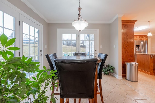 dining area with ornamental molding, a wealth of natural light, baseboards, and light tile patterned floors